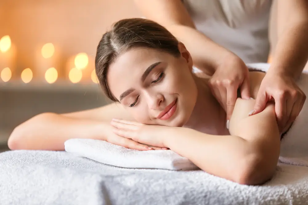 Smiling woman enjoying a calming back massage in wellness clinic
